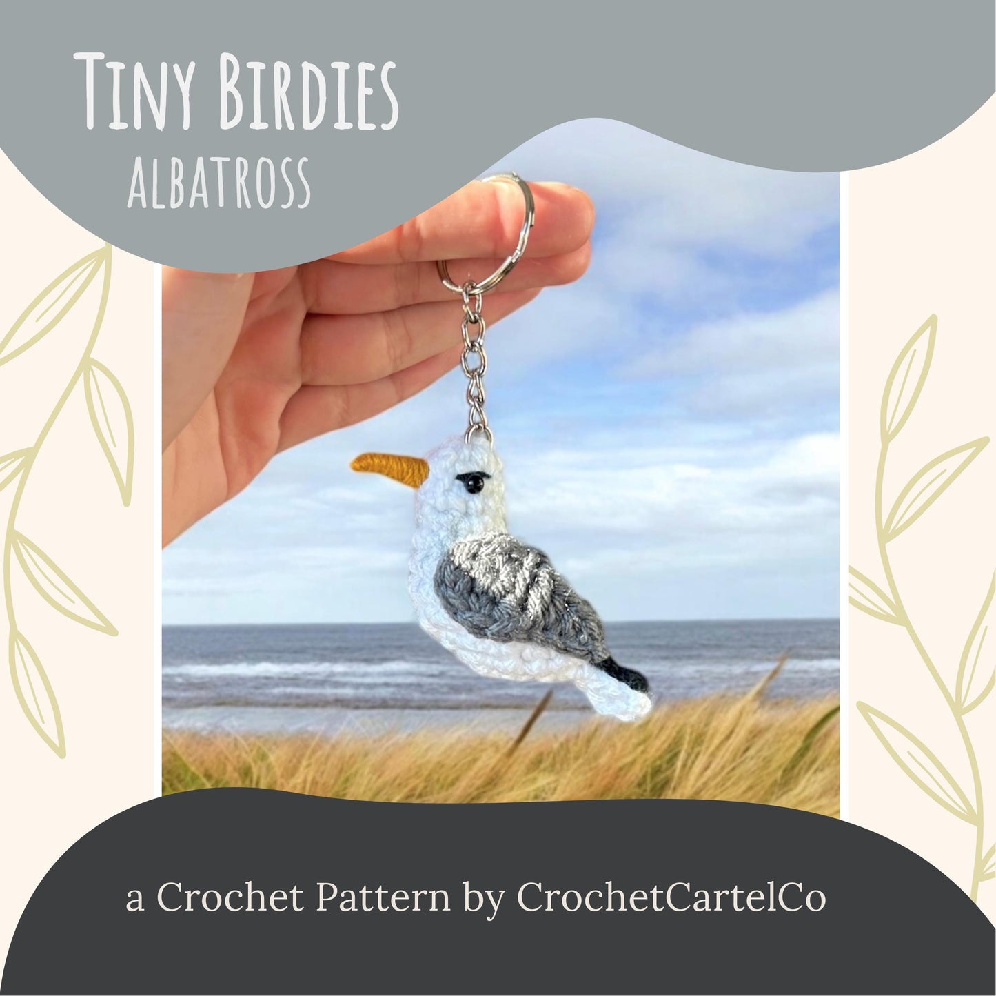 Crocheted albatross keychain crochet pattern, shown held in a hand with a scenic background