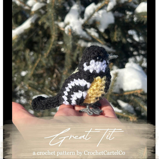 Crocheted Great Tit crochet pattern bird held in a hand with a snowy branch background