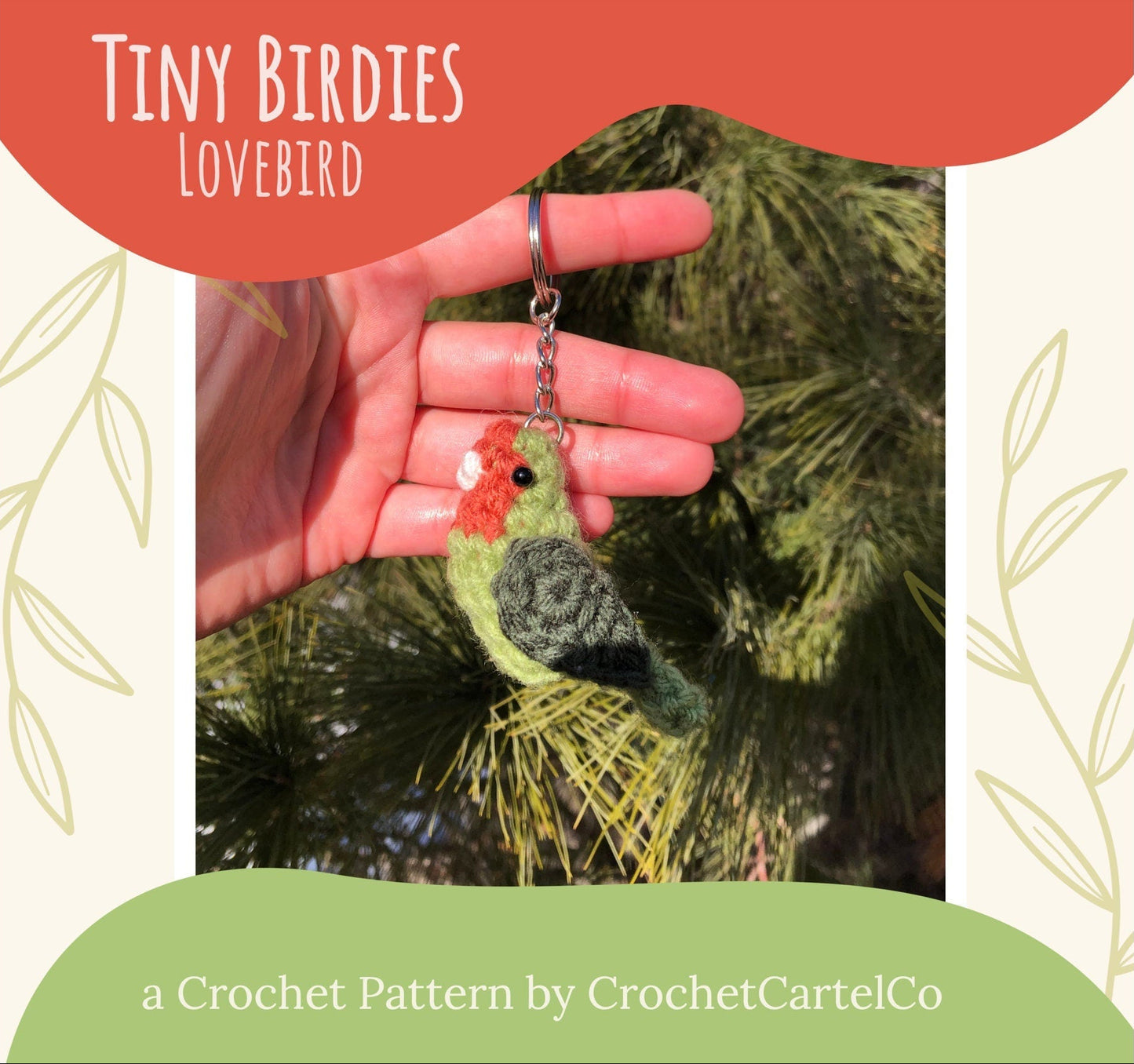 A crochet lovebird keychain crochet pattern shown held against a green background.