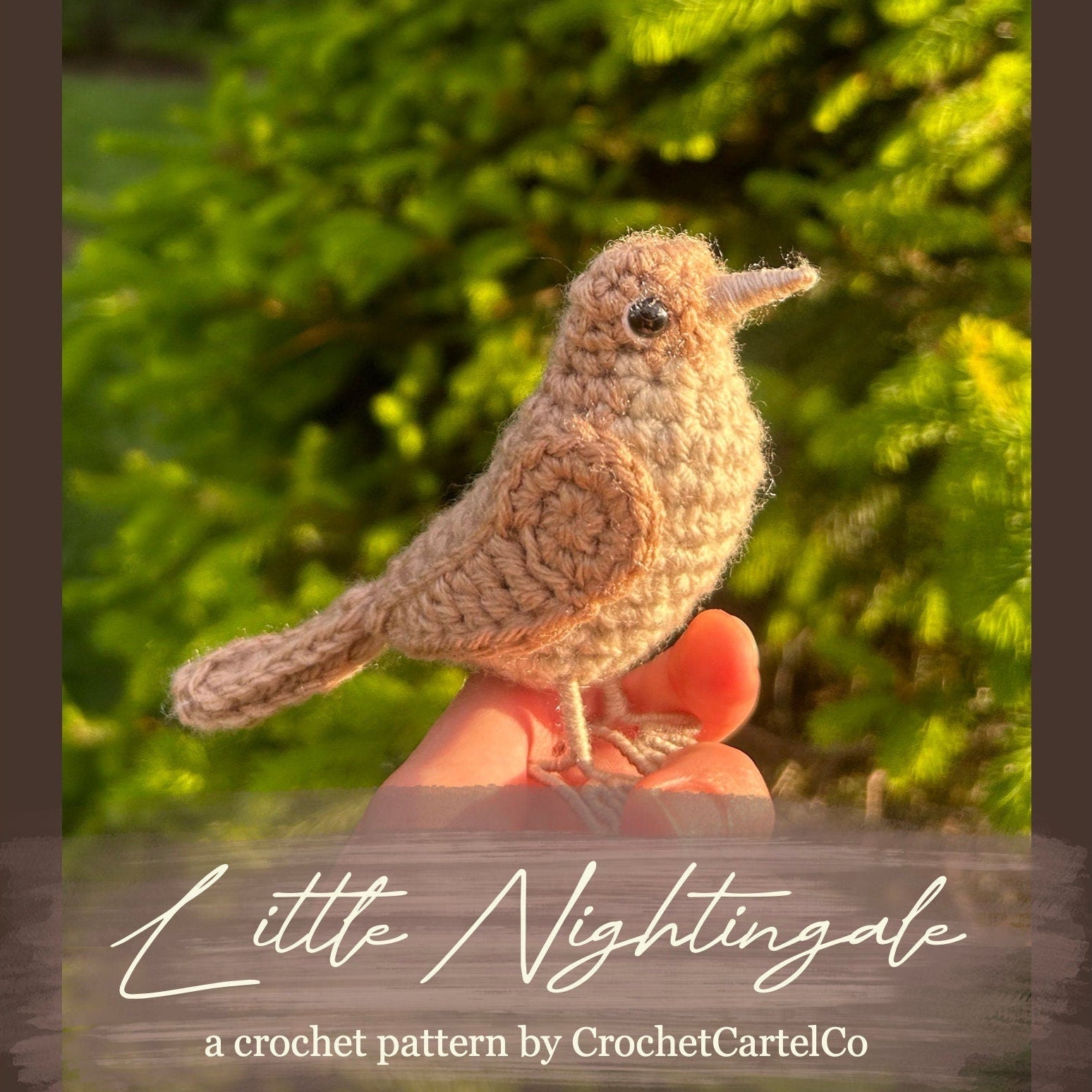 Crocheted bird pattern, shown held in a hand with a blurred green background, featuring 'Little Nightingale' by CrochetCartelCo.