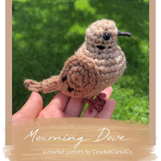 Crocheted mourning dove pattern, held in a hand with a natural background