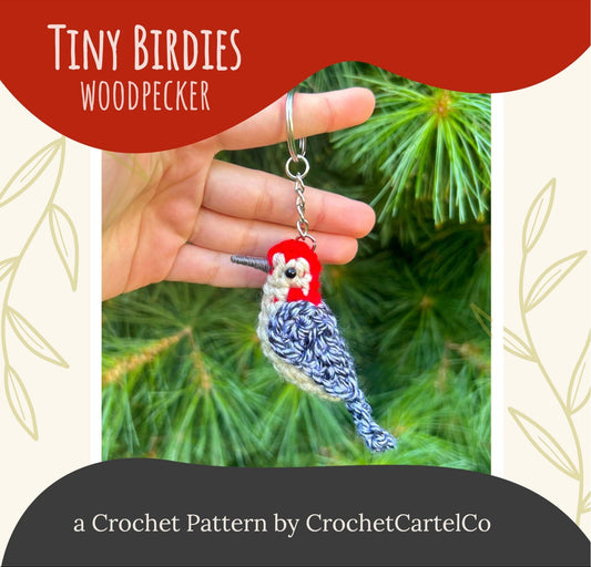 A woodpecker keychain crochet pattern shown with a red and grey design against a green leafy background.