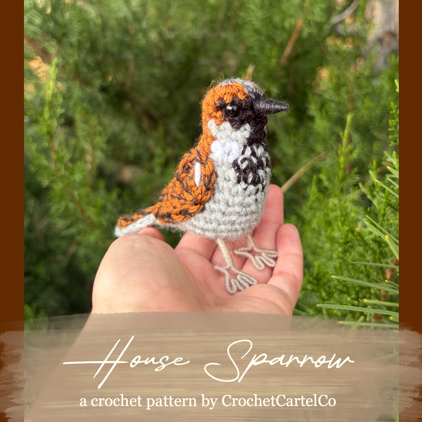 A hand holding a small crocheted bird figurine with brown, white, and black coloring, set against a blurred green outdoor background. A brown banner at the bottom reads 'House Sparrow' and 'a crochet pattern by CrochetCartelCo'.