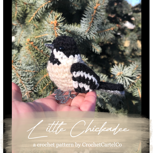 Crochet pattern for a chickadee, held in a hand with a Christmas tree background