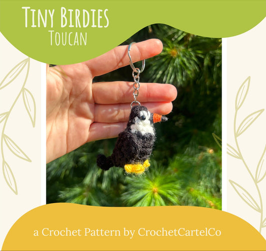 Hand holding a crochet toucan keychain with a green banner and text about the crochet pattern by CrochetCartelCo.