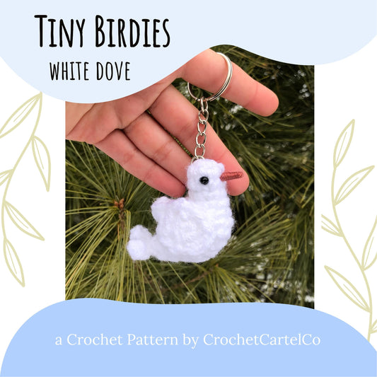 White crochet bird keychain crochet pattern shown held in a hand with a natural background