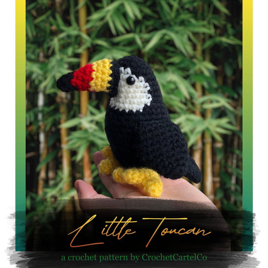 Crocheted toucan crochet pattern, shown held in a hand with a natural background