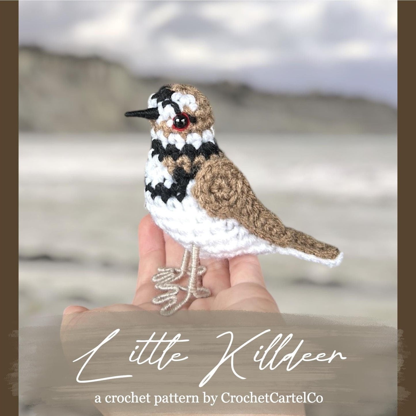 Crocheted Little Killdeer pattern, shown held in a hand with a beach background, featuring the brand 'CrochetCartelCo'.