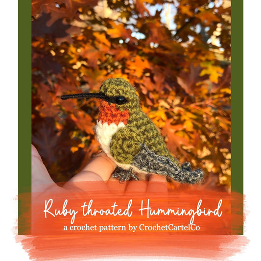 Crochet pattern for a ruby-throated hummingbird held in a hand with autumn leaves in the background